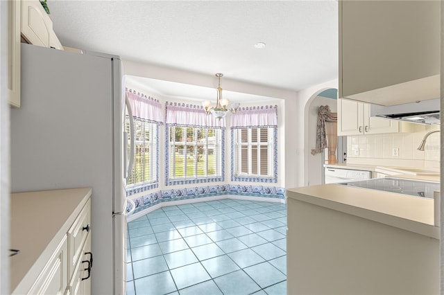 6172 SW 101st Pl, Ocala, FL 34476 - kitchen with white appliances, a chandelier, light countertops, white cabinetry, and tasteful backsplash