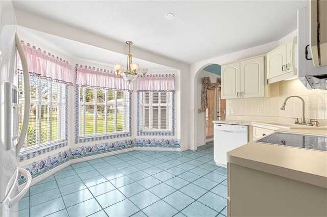 6172 SW 101st Pl, Ocala, FL 34476 - kitchen featuring white dishwasher, a chandelier, arched walkways, light countertops, and pendant lighting