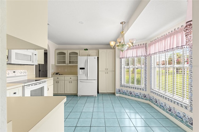 6172 SW 101st Pl, Ocala, FL 34476 - kitchen with white appliances, a chandelier, light countertops, glass insert cabinets, and tasteful backsplash