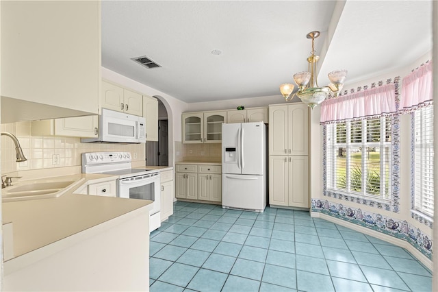 6172 SW 101st Pl, Ocala, FL 34476 - kitchen with white appliances, a chandelier, tasteful backsplash, light countertops, and glass insert cabinets