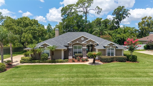 2908 SE 22nd Ave, Ocala, FL 34471 - view of front of home featuring stucco siding, a front yard, a shingled roof, and a chimney