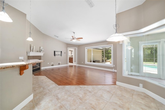 2908 SE 22nd Ave, Ocala, FL 34471 - unfurnished living room with a ceiling fan, plenty of natural light, light tile patterned floors, a fireplace with flush hearth, and high vaulted ceiling