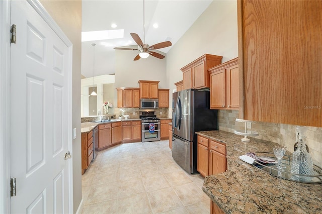 2908 SE 22nd Ave, Ocala, FL 34471 - kitchen featuring appliances with stainless steel finishes, backsplash, a ceiling fan, light stone counters, and high vaulted ceiling