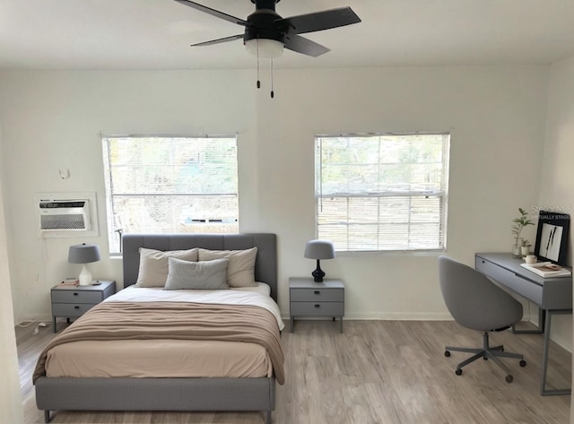 21111 SW Honeysuckle St, Dunnellon, FL 34431 - bedroom featuring wood finished floors, a wall unit AC, and a ceiling fan