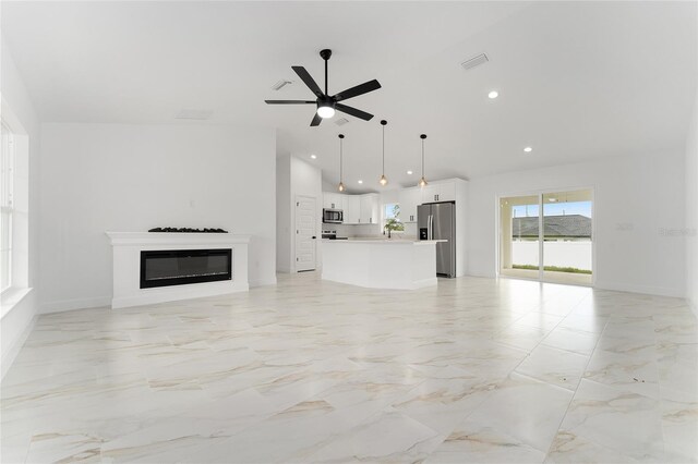 36 Pine Radl, Ocala, FL 34472 - unfurnished living room featuring ceiling fan, a glass covered fireplace, recessed lighting, light marble finish floors, and high vaulted ceiling