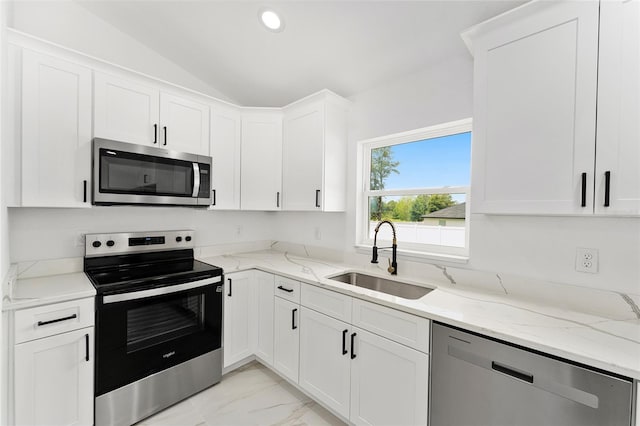 36 Pine Radl, Ocala, FL 34472 - kitchen with stainless steel appliances, light marble finish floors, white cabinetry, lofted ceiling, and light stone countertops