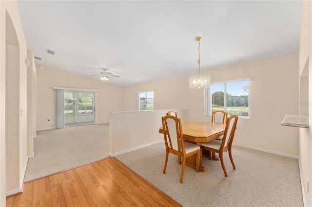 8689 SE 141st Street Rd, Summerfield, FL 34491 - dining space featuring a chandelier, light wood-style floors, lofted ceiling, ceiling fan, and light colored carpet