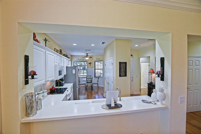 13170 SE 92nd Court Rd, Summerfield, FL 34491 - kitchen with white appliances, dark wood-type flooring, ceiling fan, light countertops, and white cabinets