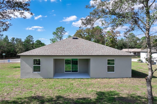 2850 W Camilo Dr, Citrus Springs, FL 34434 - back of property with stucco siding, roof with shingles, a patio area, and a lawn