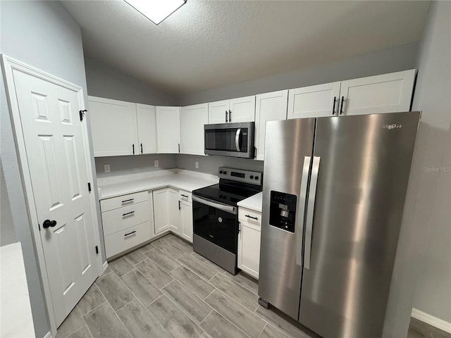 5 Laurel Pass Ln, Ocala, FL 34472 - kitchen with appliances with stainless steel finishes, light countertops, lofted ceiling, white cabinetry, and a textured ceiling