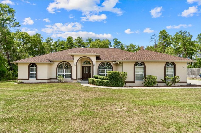 4973 SW 107th Loop, Ocala, FL 34476 - mediterranean / spanish house with stucco siding, a front yard, and a shingled roof