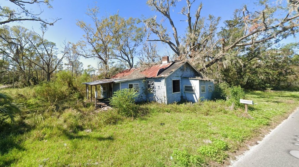823 S Warner Ave, Perry, FL 32348 - view of home's exterior with a chimney
