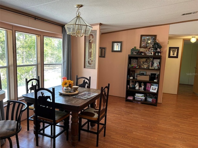5862 SW 160th Ct, Ocala, FL 34481 - dining space featuring a chandelier, crown molding, wood finished floors, and a textured ceiling
