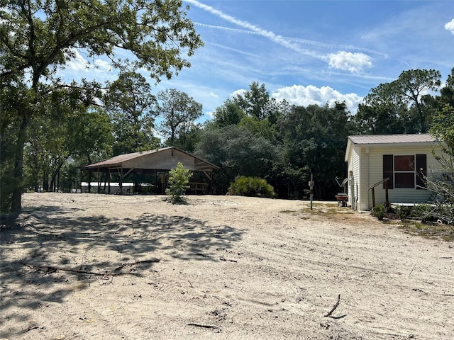 5862 SW 160th Ct, Ocala, FL 34481 - view of property exterior with a metal roof and view of wooded area