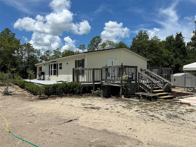 5862 SW 160th Ct, Ocala, FL 34481 - back of property with a storage unit and a wooden deck