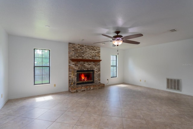 205 NE 53rd St, Ocala, FL 34479 - unfurnished living room featuring healthy amount of natural light, light tile patterned flooring, ceiling fan, and a fireplace