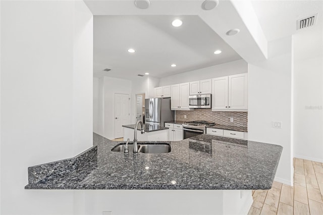 4970 NW 35th Lane Rd, Ocala, FL 34482 - kitchen with stainless steel appliances, white cabinets, recessed lighting, tasteful backsplash, and dark stone counters