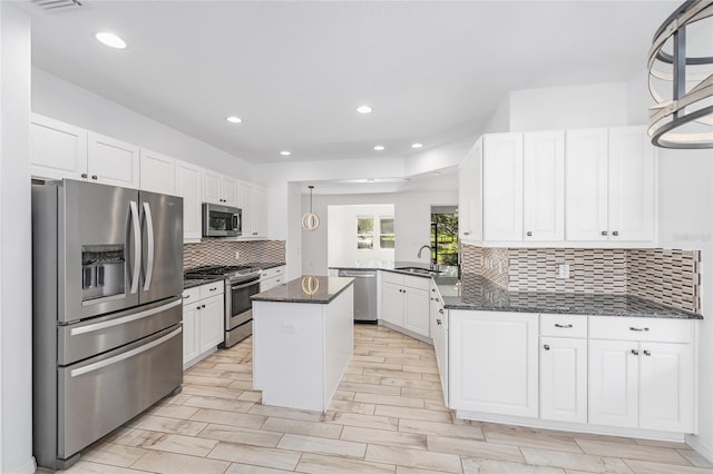 4970 NW 35th Lane Rd, Ocala, FL 34482 - kitchen featuring stainless steel appliances, white cabinets, a kitchen island, backsplash, and dark stone countertops