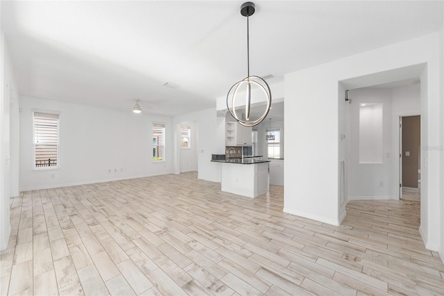 4970 NW 35th Lane Rd, Ocala, FL 34482 - kitchen with open floor plan, dark countertops, light wood finished floors, and healthy amount of natural light