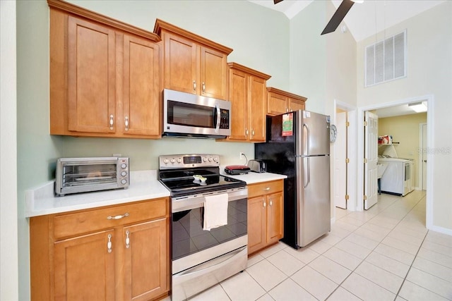 5459 SW 86th St, Ocala, FL 34476 - kitchen with appliances with stainless steel finishes, separate washer and dryer, a towering ceiling, light countertops, and light tile patterned floors