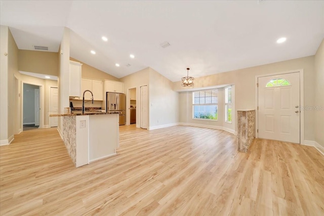6631 SE 11th Loop, Ocala, FL 34472 - kitchen featuring stainless steel fridge with ice dispenser, a chandelier, white cabinets, a peninsula, and light wood-style flooring