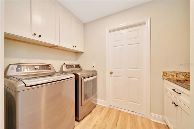 6631 SE 11th Loop, Ocala, FL 34472 - washroom featuring washer and clothes dryer, light wood finished floors, and cabinet space