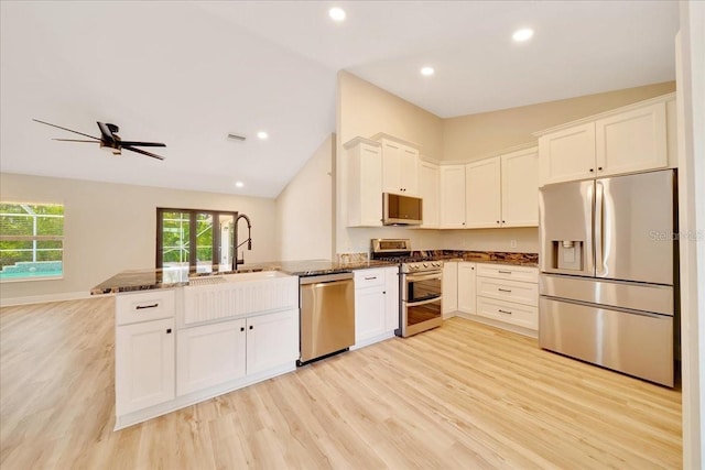 6631 SE 11th Loop, Ocala, FL 34472 - kitchen with stainless steel appliances, a peninsula, light wood finished floors, vaulted ceiling, and dark stone countertops