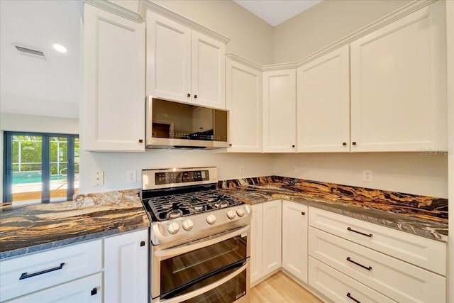 6631 SE 11th Loop, Ocala, FL 34472 - kitchen featuring appliances with stainless steel finishes, dark stone countertops, white cabinetry, light wood finished floors, and recessed lighting
