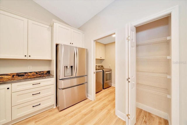 6631 SE 11th Loop, Ocala, FL 34472 - kitchen with stainless steel fridge, independent washer and dryer, light wood-style flooring, white cabinetry, and vaulted ceiling
