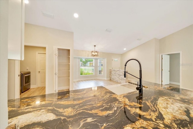 6631 SE 11th Loop, Ocala, FL 34472 - kitchen with wood finished floors, dark stone counters, a chandelier, lofted ceiling, and hanging light fixtures