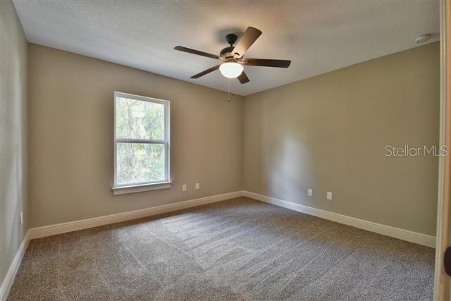 3168 SE 141st Pl, Summerfield, FL 34491 - carpeted empty room featuring a ceiling fan and a smoke detector
