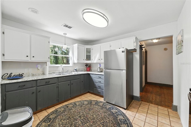 5693 Payette Ave, Keystone Heights, FL 32656 - kitchen with freestanding refrigerator, gray cabinets, white cabinets, and hanging light fixtures