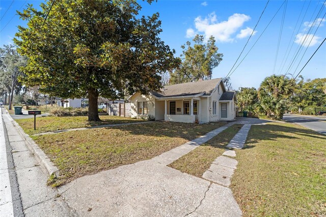 114 NE 11th Ave, Ocala, FL 34470 - view of front of house with a front yard, driveway, and stucco siding