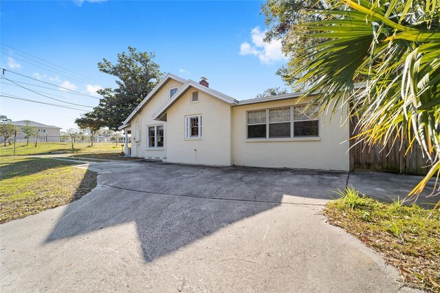 114 NE 11th Ave, Ocala, FL 34470 - view of home's exterior featuring stucco siding, a patio area, and a chimney