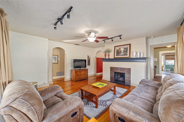 114 NE 11th Ave, Ocala, FL 34470 - living room with rail lighting, arched walkways, light wood finished floors, and ceiling fan
