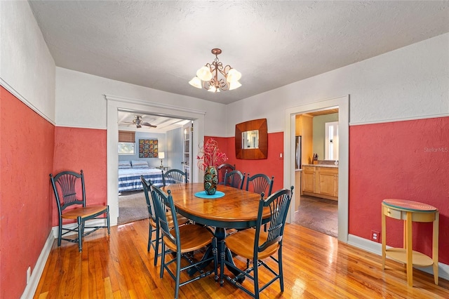 114 NE 11th Ave, Ocala, FL 34470 - dining space with light wood-type flooring, a chandelier, a textured wall, ceiling fan, and a textured ceiling