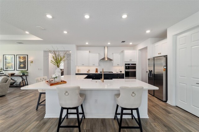 9746 SW 108th Terrace Rd, Ocala, FL 34481 - kitchen with stainless steel appliances, wall chimney range hood, open floor plan, a breakfast bar, and a large island