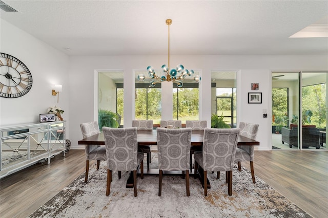 9746 SW 108th Terrace Rd, Ocala, FL 34481 - dining room featuring wood finished floors, healthy amount of natural light, and a chandelier