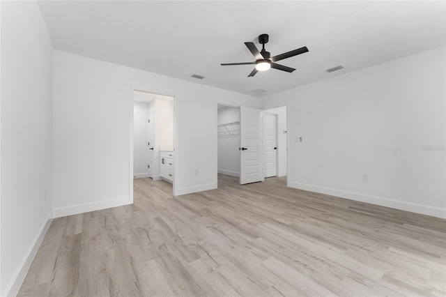 28 Water Track Dr, Ocala, FL 34472 - unfurnished bedroom with light wood finished floors, ensuite bath, a walk in closet, ceiling fan, and a closet