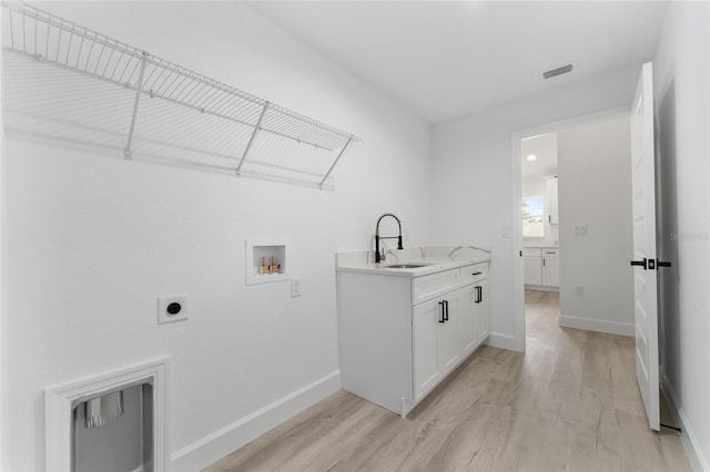 28 Water Track Dr, Ocala, FL 34472 - laundry area with hookup for an electric dryer, light wood-style floors, washer hookup, and cabinet space