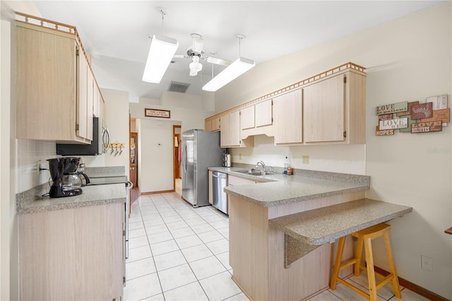 7443 SW 102nd Pl, Ocala, FL 34476 - kitchen featuring stainless steel appliances, a peninsula, a ceiling fan, a kitchen breakfast bar, and light countertops