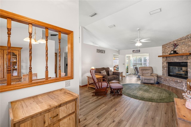 7443 SW 102nd Pl, Ocala, FL 34476 - living area with vaulted ceiling, a ceiling fan, wood finished floors, and a brick fireplace