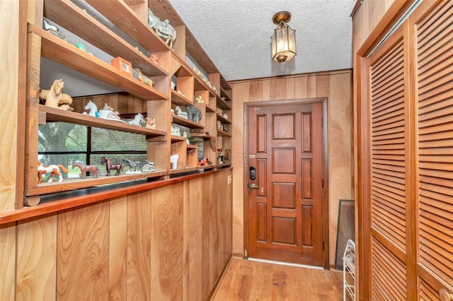 2676 SE 52nd Ave, Ocala, FL 34480 - doorway featuring light wood finished floors, wooden walls, and a textured ceiling