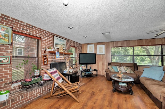 2676 SE 52nd Ave, Ocala, FL 34480 - living room featuring brick wall, a textured ceiling, wood finished floors, and a brick fireplace
