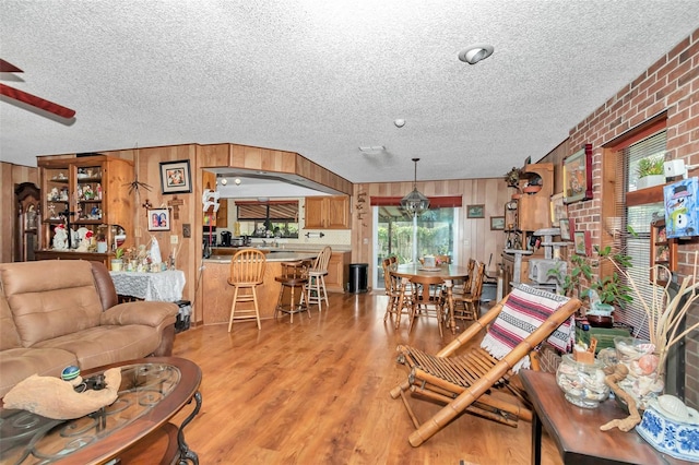 2676 SE 52nd Ave, Ocala, FL 34480 - living room with a textured ceiling, a ceiling fan, light wood-style floors, and wooden walls