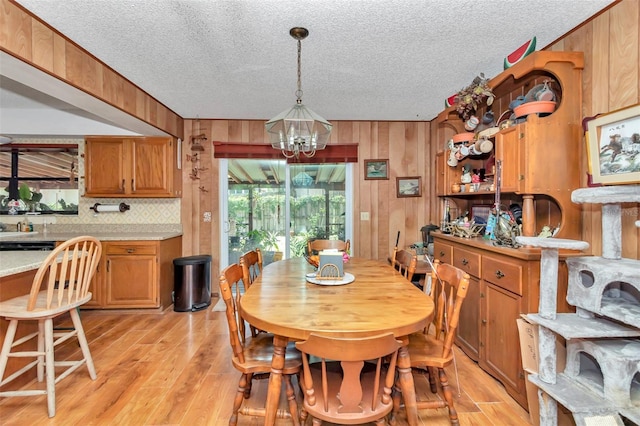 2676 SE 52nd Ave, Ocala, FL 34480 - dining room with a textured ceiling, a chandelier, healthy amount of natural light, wooden walls, and light wood finished floors