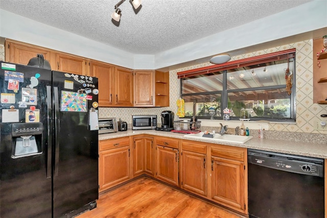 2676 SE 52nd Ave, Ocala, FL 34480 - kitchen featuring black appliances, a textured ceiling, light countertops, decorative backsplash, and light wood-type flooring