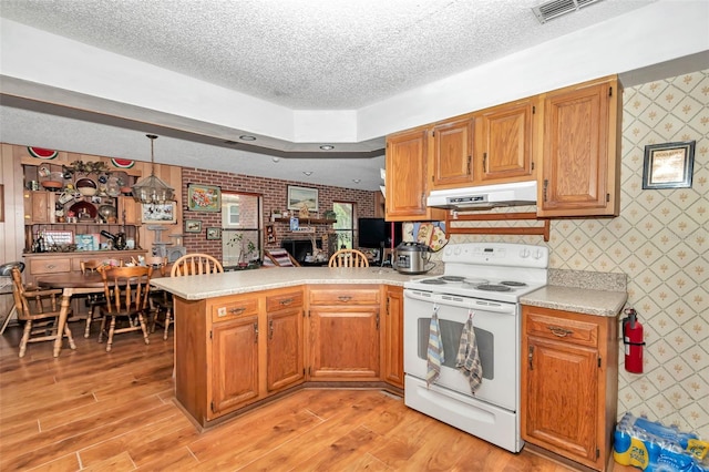 2676 SE 52nd Ave, Ocala, FL 34480 - kitchen featuring white range with electric cooktop, wallpapered walls, under cabinet range hood, light countertops, and a peninsula