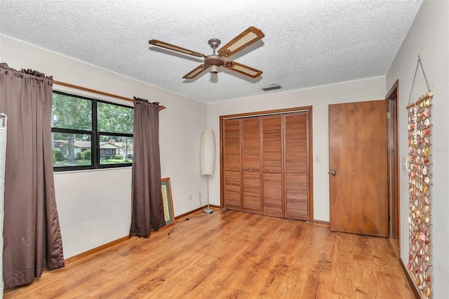 2676 SE 52nd Ave, Ocala, FL 34480 - unfurnished bedroom featuring a textured ceiling, light wood finished floors, and a ceiling fan