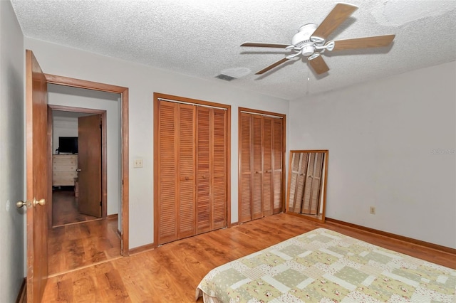 2676 SE 52nd Ave, Ocala, FL 34480 - bedroom featuring two closets, light wood-type flooring, a textured ceiling, and ceiling fan